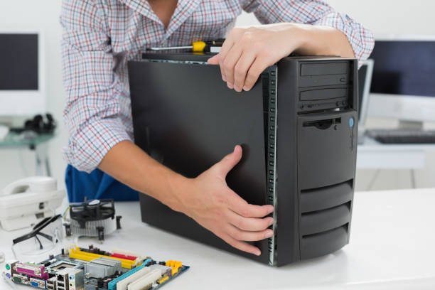 young technician working on broken computer in his office